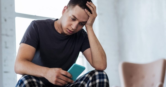 Stressed Man Looking at Phone